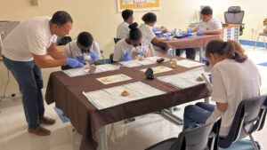 A veterinarian guides Camden students using eye examination instruments at a classroom demonstration.